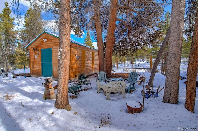 snowy yard featuring a storage shed