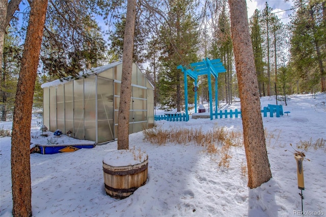 yard layered in snow featuring an outdoor structure