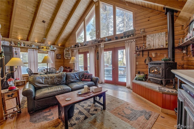 living room featuring french doors, light wood-type flooring, beam ceiling, wooden ceiling, and a wood stove