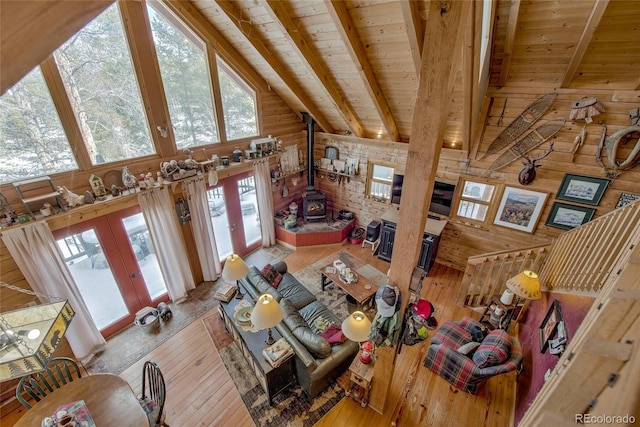 living room featuring beamed ceiling, hardwood / wood-style flooring, wooden walls, and wood ceiling