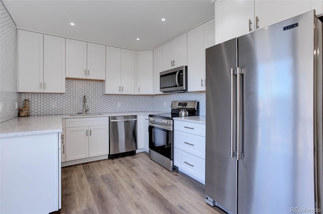 kitchen featuring stainless steel appliances, white cabinets, and a sink