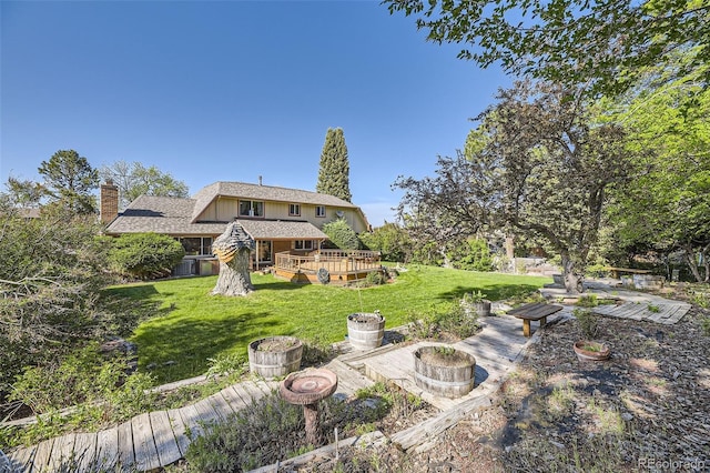 6708 W Portland Ave, Littleton, CO 80128 - back of property with a deck, a chimney, a lawn, and a fire pit