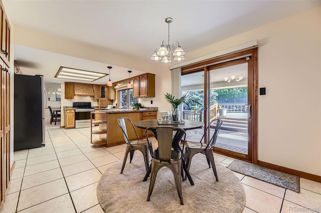 6708 W Portland Ave, Littleton, CO 80128 - dining area with light tile patterned flooring, a chandelier, plenty of natural light, and baseboards