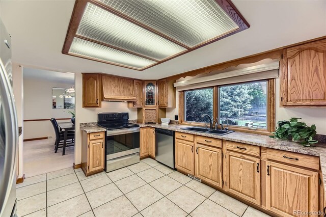 6708 W Portland Ave, Littleton, CO 80128 - kitchen featuring stainless steel appliances, a sink, light tile patterned floors, and light countertops