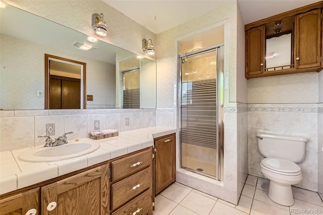6708 W Portland Ave, Littleton, CO 80128 - bathroom featuring tile walls, vanity, tile patterned flooring, a shower stall, and toilet