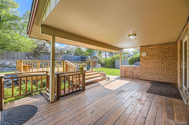 6708 W Portland Ave, Littleton, CO 80128 - wooden deck featuring a fenced backyard, a storage shed, and an outdoor structure