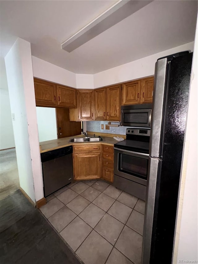 31270 John Wallace Rd Unit 306, Evergreen, CO 80439 - kitchen with appliances with stainless steel finishes, brown cabinets, light tile patterned floors, and light countertops