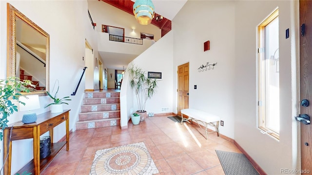 entryway featuring light tile patterned floors and a high ceiling