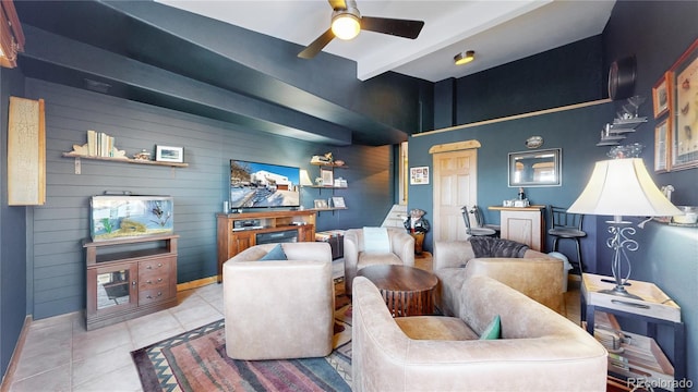 tiled living room featuring ceiling fan, beam ceiling, and wooden walls