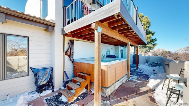 view of patio / terrace with a balcony and a hot tub