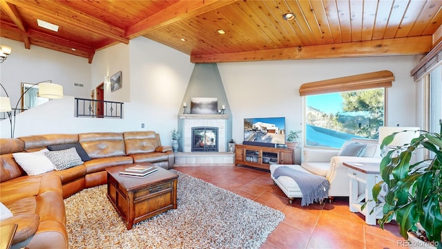 living room with a tiled fireplace, wooden ceiling, beamed ceiling, and tile patterned flooring