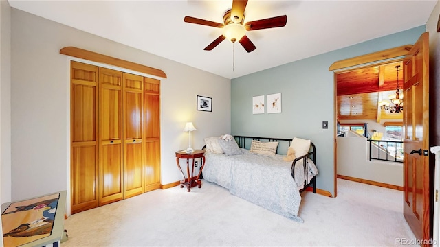 bedroom featuring ceiling fan, light colored carpet, and a closet