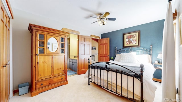 carpeted bedroom with ceiling fan, ensuite bath, and a closet