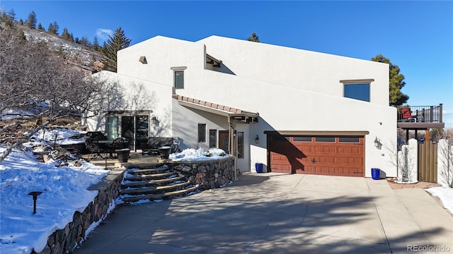 snow covered property with a garage