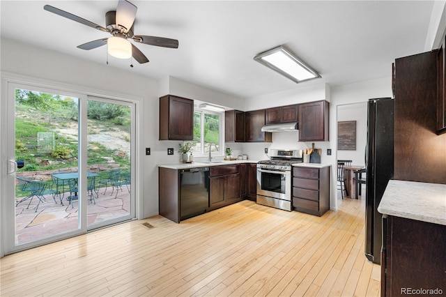 229 Berthoud Way, Golden, CO 80401 - kitchen with black appliances, under cabinet range hood, light countertops, and dark brown cabinets