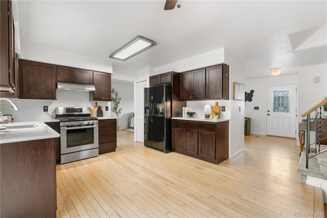 229 Berthoud Way, Golden, CO 80401 - kitchen with stainless steel range with gas stovetop, black refrigerator with ice dispenser, under cabinet range hood, dark brown cabinetry, and light countertops