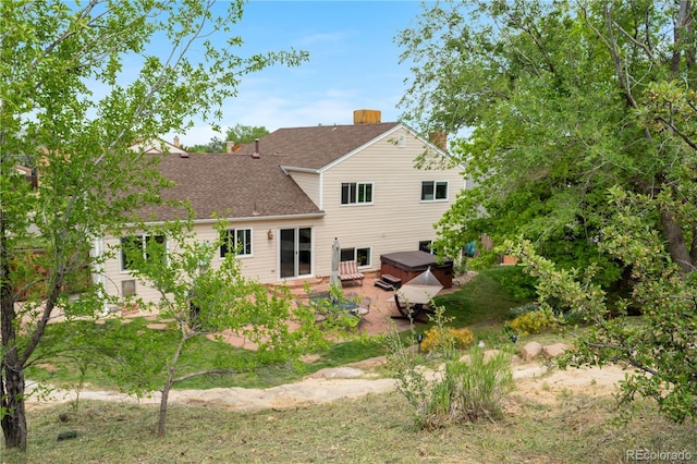 229 Berthoud Way, Golden, CO 80401 - rear view of house with a hot tub, a patio area, a shingled roof, and a chimney