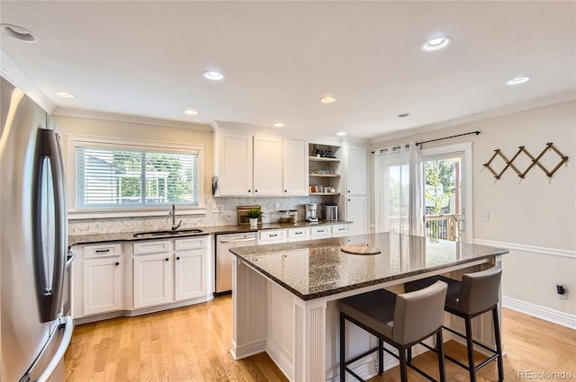 702 Windmill Pl, Highlands Ranch, CO 80126 - kitchen with appliances with stainless steel finishes, ornamental molding, healthy amount of natural light, open shelves, and decorative backsplash