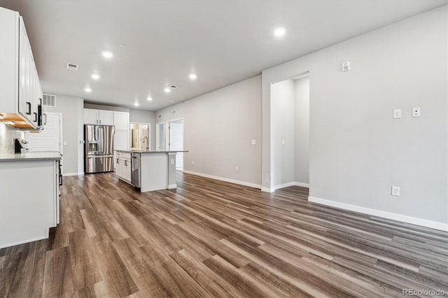 kitchen featuring a center island with sink, visible vents, white cabinets, dark wood-style flooring, and stainless steel appliances