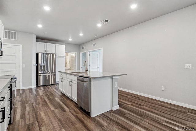 kitchen with visible vents, dark wood finished floors, white cabinets, appliances with stainless steel finishes, and a sink