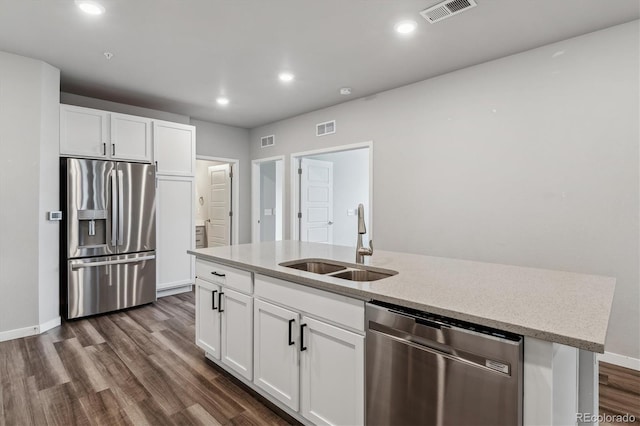 kitchen with stainless steel appliances, dark wood-type flooring, a sink, and visible vents