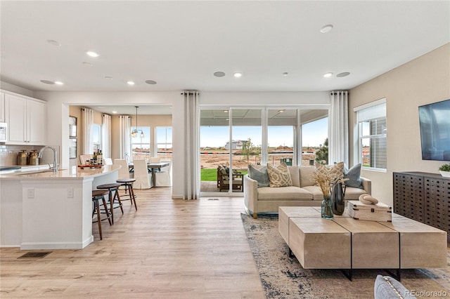 living room featuring recessed lighting, visible vents, and light wood finished floors