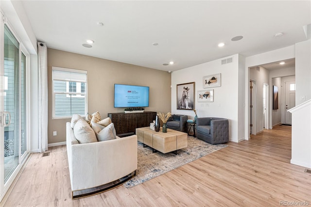 living area featuring light wood finished floors, baseboards, visible vents, and recessed lighting