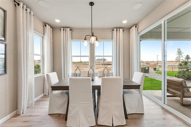 dining area featuring light wood-style floors, recessed lighting, a notable chandelier, and baseboards