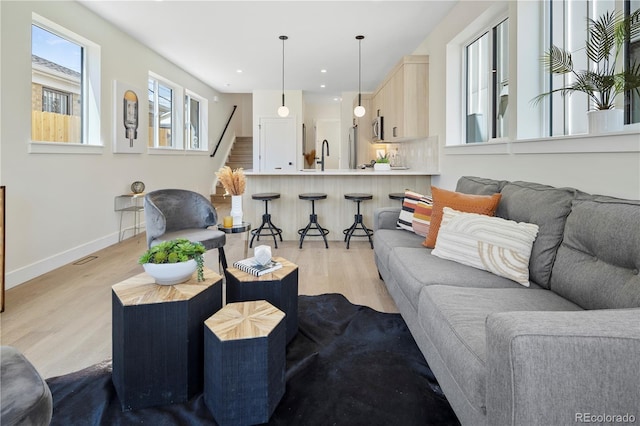 living room with sink and light wood-type flooring