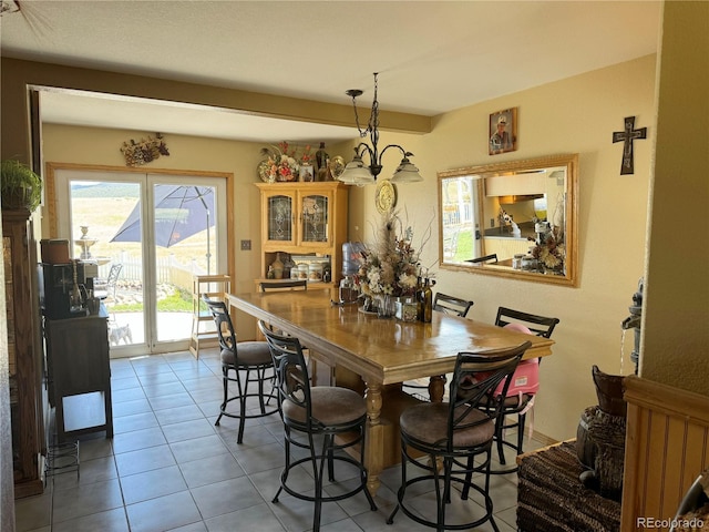 dining area featuring light tile patterned flooring and a notable chandelier