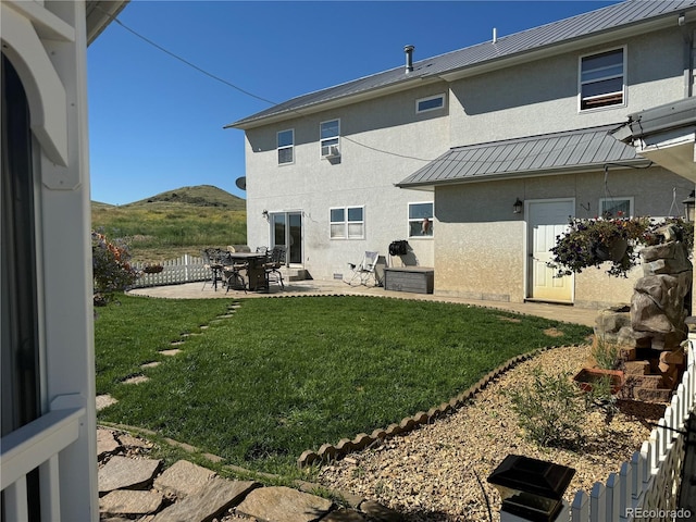 rear view of house featuring a lawn, a patio area, and a mountain view