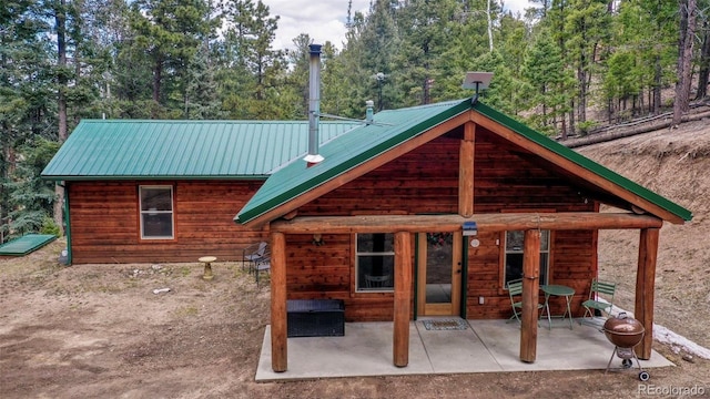 back of house with a patio area and metal roof