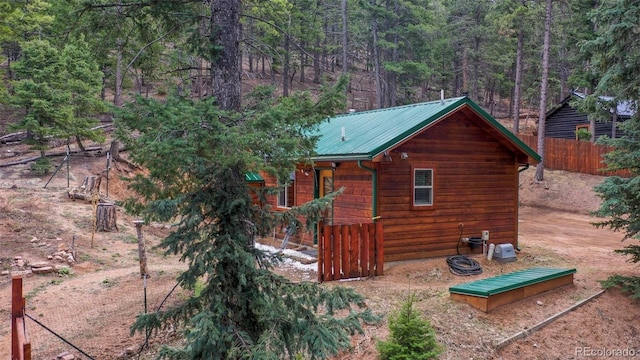 155 Squilchuck Trl, Woodland Park, CO 80863 - view of home's exterior with fence, a view of trees, and metal roof