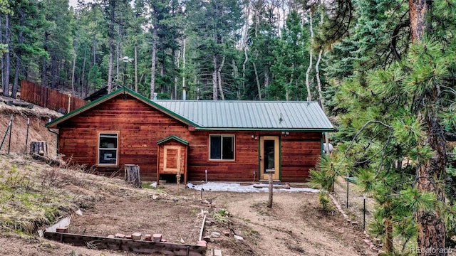 155 Squilchuck Trl, Woodland Park, CO 80863 - view of front of house with fence, a view of trees, and metal roof