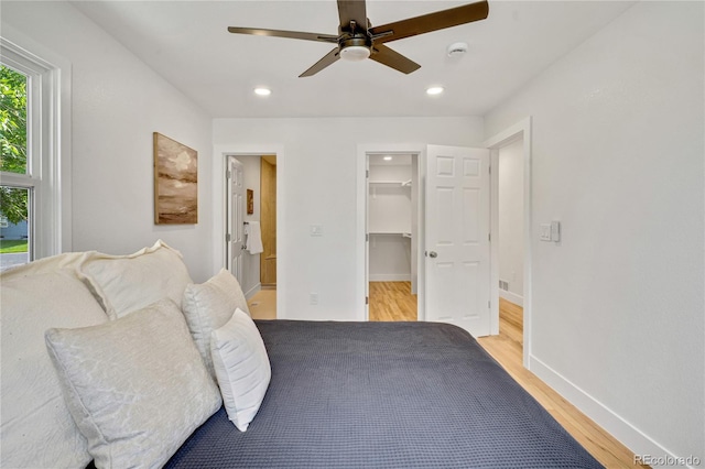 2701 Barnhart St, Thornton, CO 80229 - bedroom featuring light wood finished floors, a walk in closet, baseboards, recessed lighting, and a ceiling fan