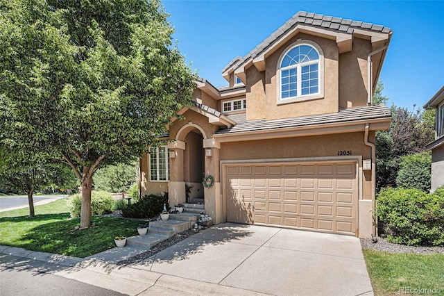 12051 E Lake Cir, Greenwood Village, CO 80111 - view of front of home featuring stucco siding, concrete driveway, an attached garage, and a tiled roof