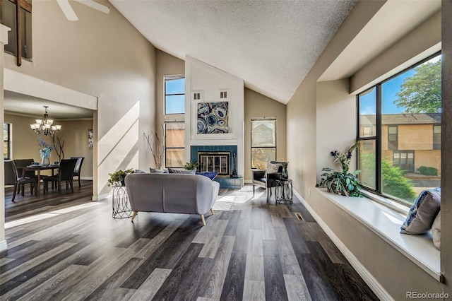 living room featuring a textured ceiling, high vaulted ceiling, dark hardwood / wood-style flooring, and a fireplace