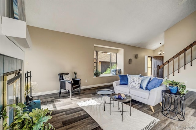 living room featuring wood-type flooring, a chandelier, a textured ceiling, and vaulted ceiling