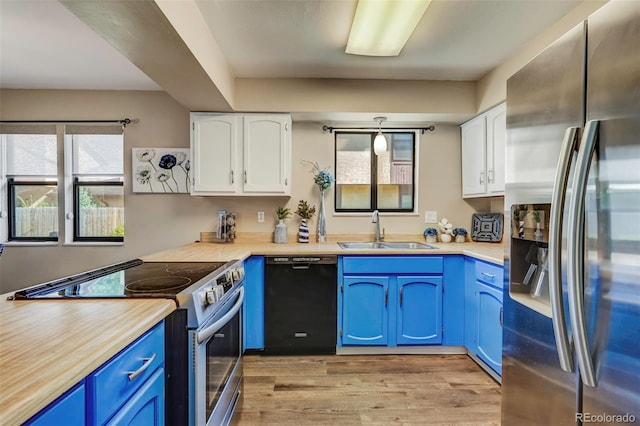 kitchen with sink, appliances with stainless steel finishes, white cabinetry, and blue cabinetry