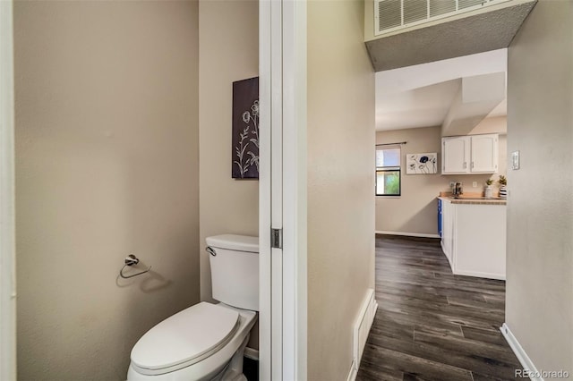 bathroom with toilet and wood-type flooring