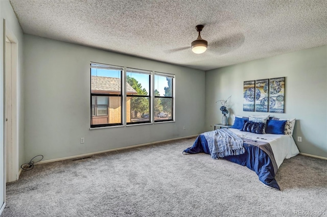 bedroom featuring a textured ceiling, ceiling fan, and carpet