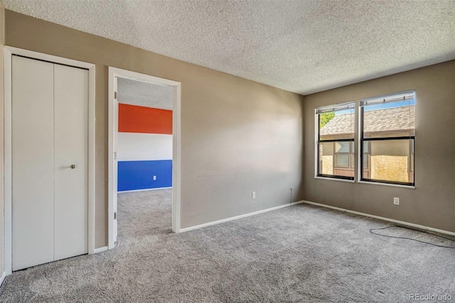 unfurnished bedroom with a textured ceiling, carpet flooring, and a closet