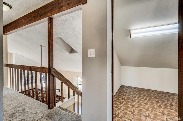 bonus room with a textured ceiling, parquet floors, and lofted ceiling