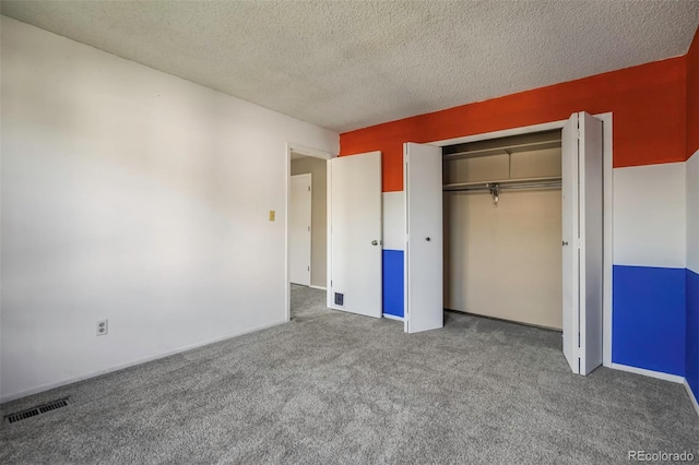 unfurnished bedroom featuring a closet, a textured ceiling, and carpet flooring