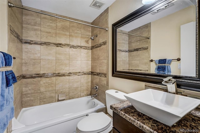 full bathroom featuring toilet, tiled shower / bath combo, and vanity