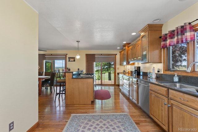 kitchen featuring dishwasher, sink, a breakfast bar area, hanging light fixtures, and a center island