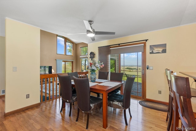 dining space with ceiling fan, vaulted ceiling, and light wood-type flooring