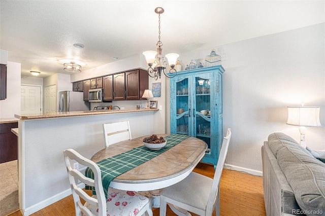 5252 W 68th Ave, Arvada, CO 80003 - dining area with a chandelier, light wood-style floors, and baseboards