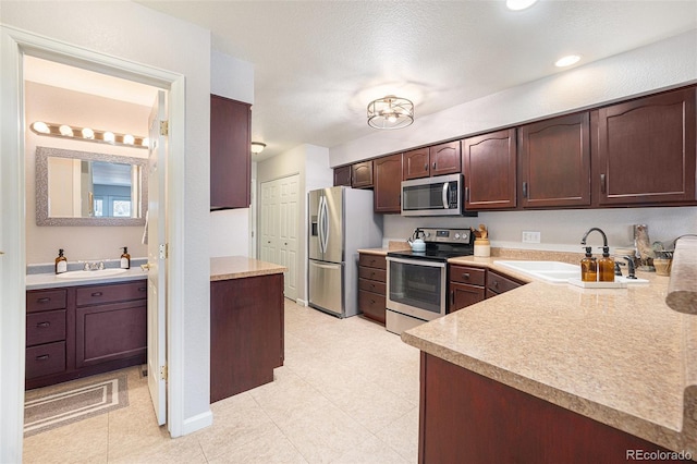 5252 W 68th Ave, Arvada, CO 80003 - kitchen featuring appliances with stainless steel finishes, a sink, light countertops, dark brown cabinetry, and recessed lighting