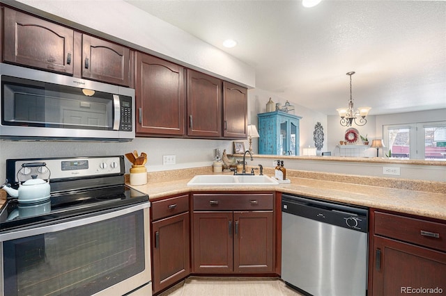 5252 W 68th Ave, Arvada, CO 80003 - kitchen featuring stainless steel appliances, a sink, light countertops, a chandelier, and pendant lighting